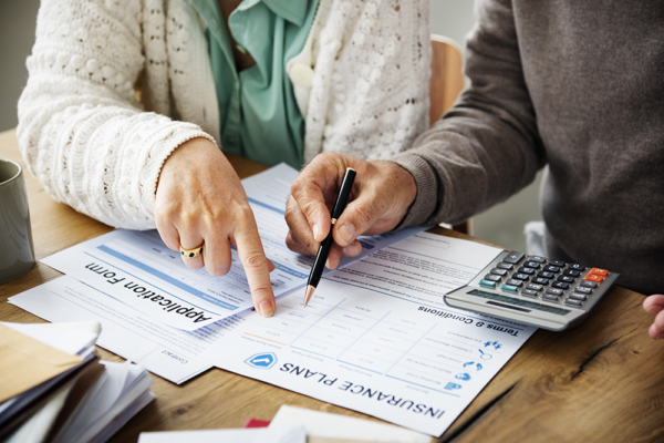 two people filling out insurance forms