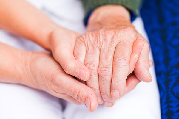 Young carer giving helping hands for elderly woman