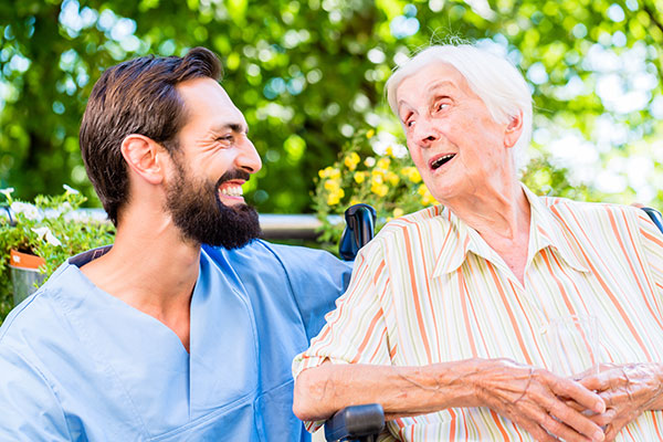 Nurse having chat with senior woman in nursing home