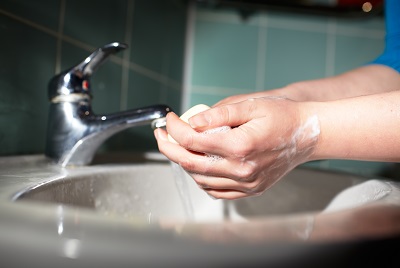 close up of person washing hands in bathroom