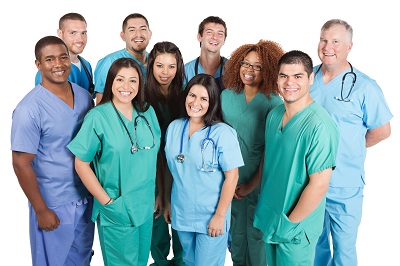 group of different race and aged nurses in blue and green scrubs standing for photo