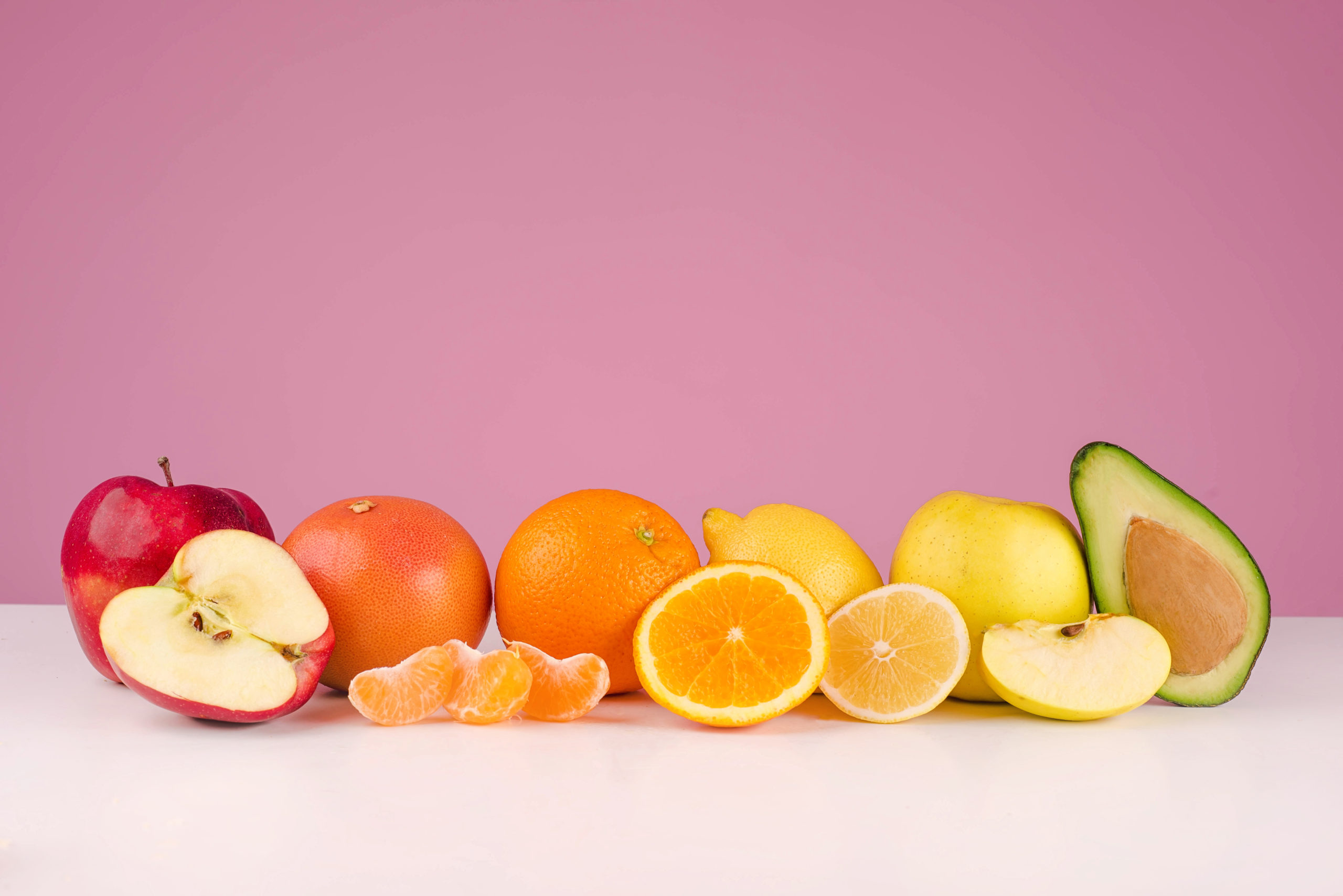 colorful fruits like red apples bright oranges yellow lemons and green avacados