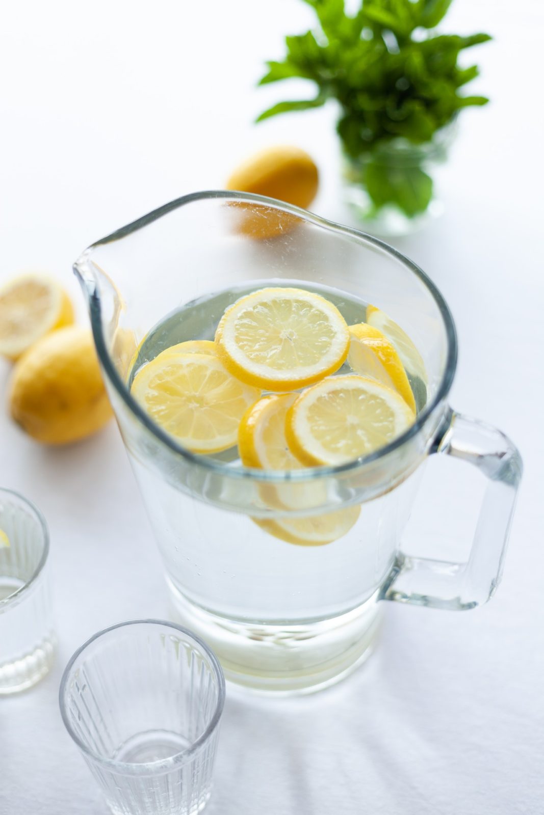 large clear pitcher of water with slices of lemon
