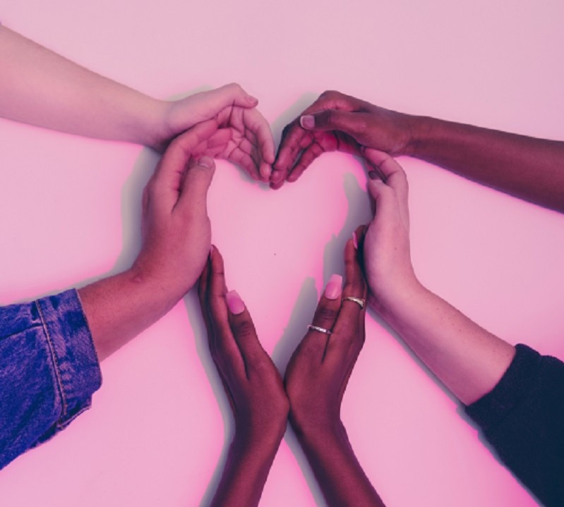 group of friends using their hands to make a heart shape