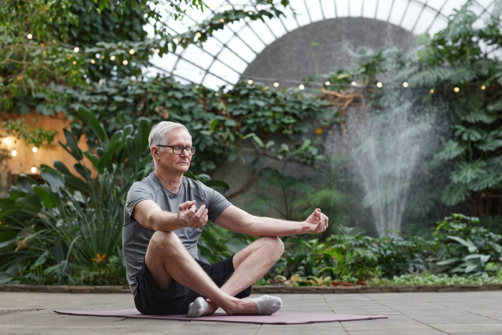 senior man meditating in a garden