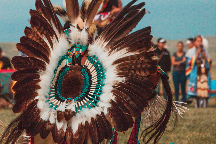 Large Native American headdress with brown and white feathers decorated with teal beading