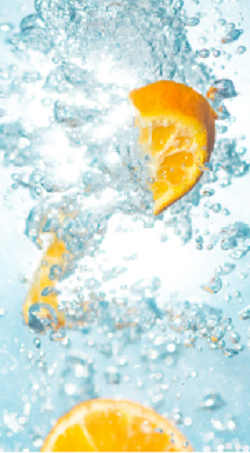two bright yellow lemon wedges dropped into bubbly water
