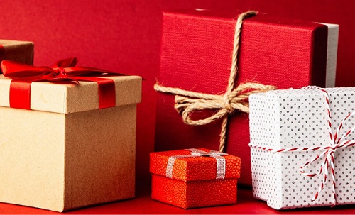 gift boxes in brown red white tied with twine sitting on red background