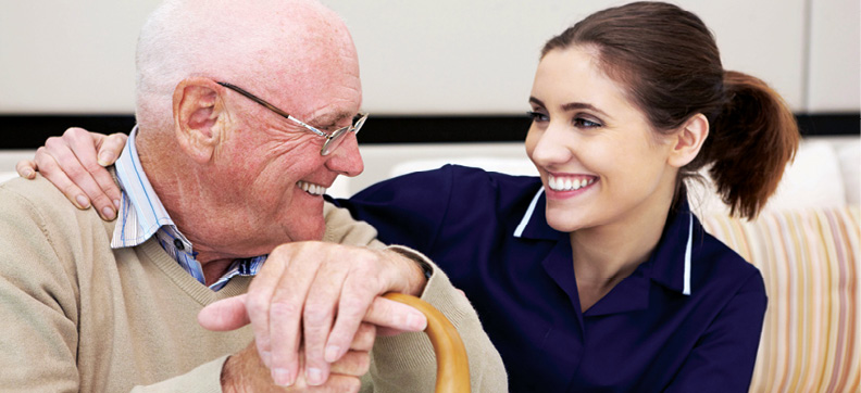 senior man smiling and sitting with a young female clinical professional