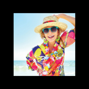Senior woman on the beach in beach shirt, beach hat, and sunglasses.
