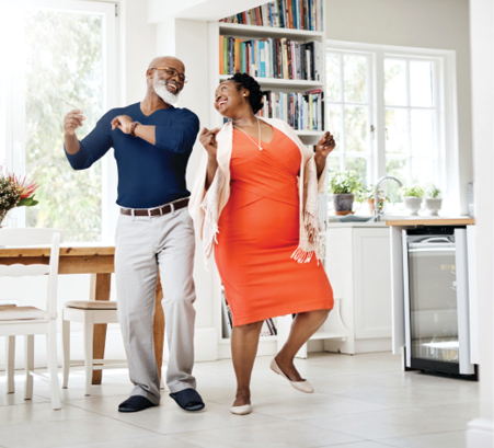 African American couple smiling and dancing in kitchen