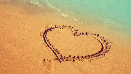 heart drawn in sand on beach