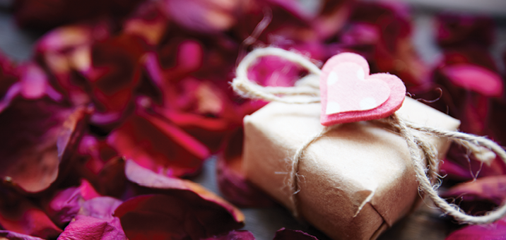 image of wrapped valentines present surrounded by hot pink rose pedals