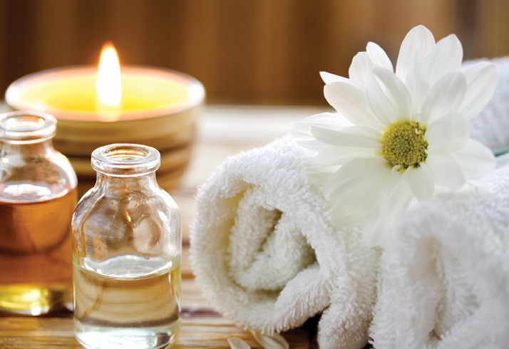 image of essential oils, candles, and towels for a spa day