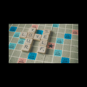 scrabble board with words spelling love yourself